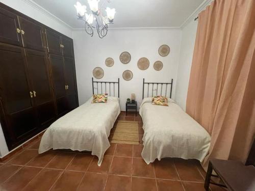 duas camas sentadas uma ao lado da outra num quarto em Casa con piscina privada em Sevilha