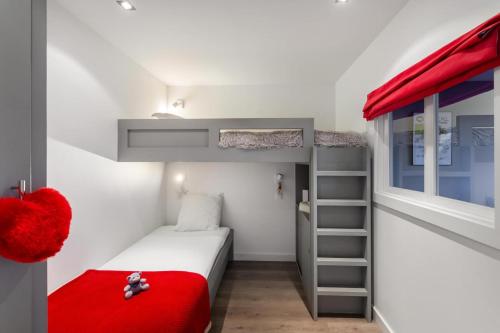 Dormitorio pequeño con litera y manta roja en Residence - Studio 514 en Courchevel