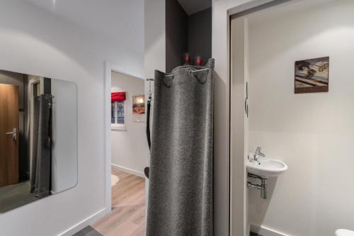 y baño con cortina de ducha y lavamanos. en Residence - Studio 514 en Courchevel