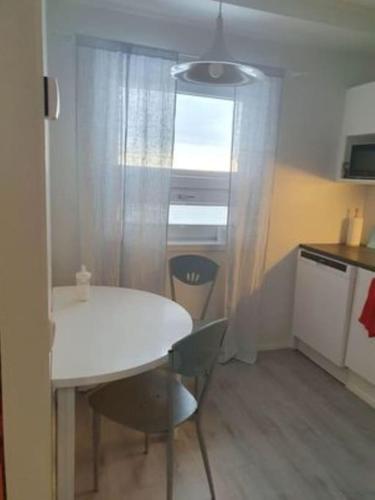 een kleine keuken met een witte tafel en stoelen bij Yksiö luonnonläheisyydessä in Seinäjoki