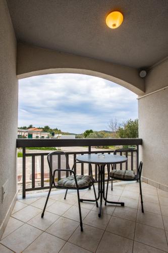 a patio with a table and chairs on a balcony at Sunset Apartman Ana in Zaboric