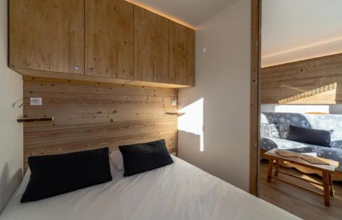 a bedroom with a bed with a wooden wall at Résidence Les Lauzieres - 2 Pièces pour 4 Personnes 394 in Val Thorens