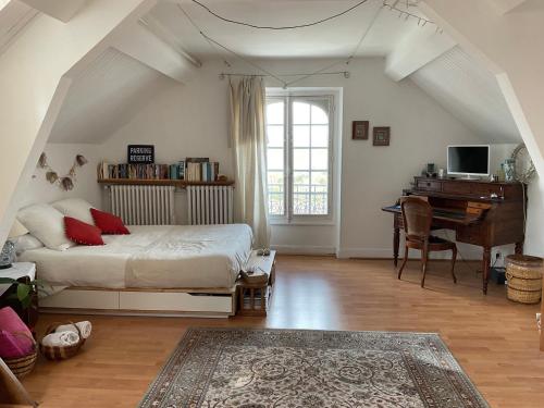 um quarto com uma cama, uma secretária e um piano em Atelier chez Marie em Carnetin