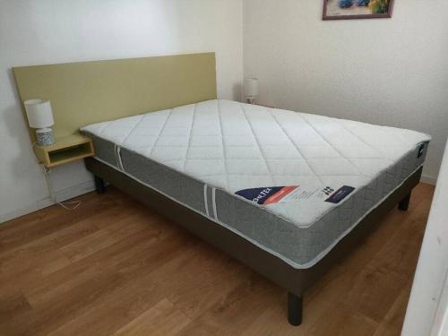 Cette chambre comprend un grand lit avec un matelas. dans l'établissement Appartement avec accès piscine, proximité mer, au Grau-du-Roi