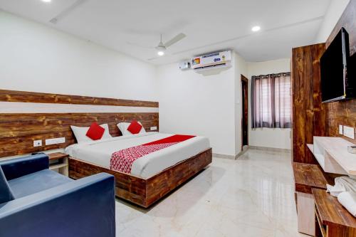 1 dormitorio con 1 cama grande y 1 silla azul en Collection O Hotel Vihari Grand, en Vijayawāda