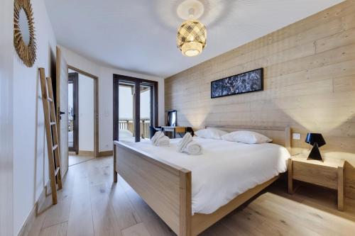 1 dormitorio con 1 cama grande y pared de madera en Résidence Les Alpages - Pièces 884, en La Rosière