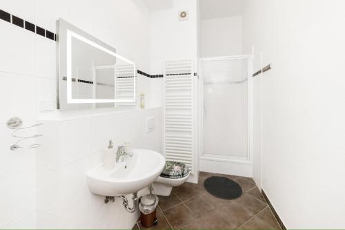 a white bathroom with a sink and a shower at Great Central City Apartments Mitte Museumsinsel in Berlin