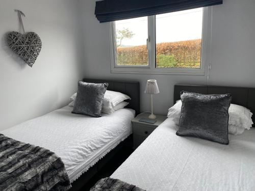 um quarto com 2 camas individuais e uma janela em Chalet 12a em Seaton