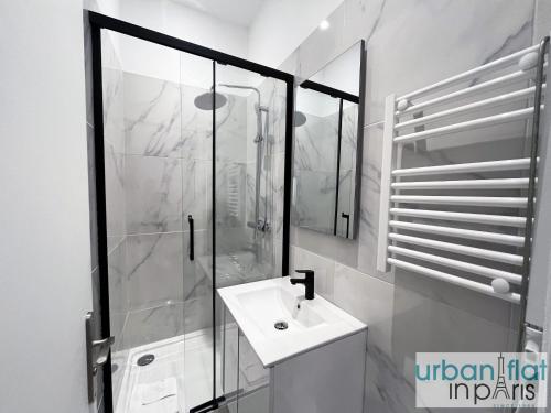 une salle de bain blanche avec une douche et un lavabo dans l'établissement Urban Flat 01 - Charming 2 bedroom Flat in Montorgueil, à Paris