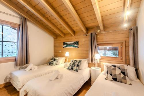 2 Betten in einem Zimmer mit Holzwänden in der Unterkunft Résidence Les Balcons Des Bois Venants Bat A - Pièces 444 in Morzine