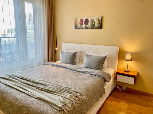 1 dormitorio con 1 cama grande y ventana grande en Cozy Foorum Apartment - Tallinn City Centre, en Tallin