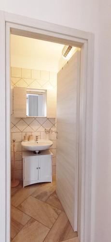 a bathroom with a white sink and a mirror at La casa di Cry in Cagliari