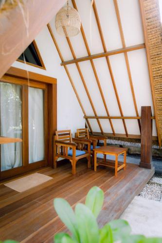 a living room with wooden furniture and a ceiling at Island View Bar & Bungalow in Gili Air