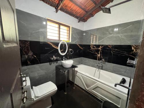 a bathroom with a tub and a sink and a toilet at Stillwater Homestay in Chikmagalūr