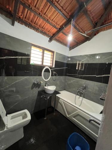 a bathroom with a sink and a toilet and a tub at Stillwater Homestay in Chikmagalūr