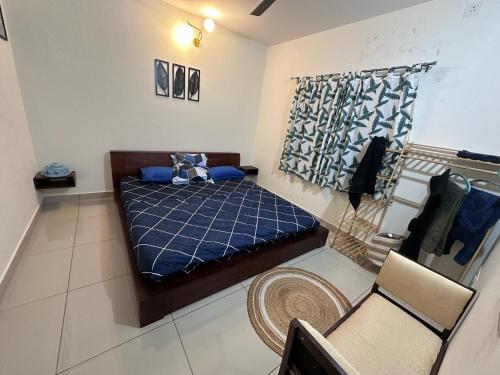 a small bedroom with a bed and a chair at Tranquil Haven Retreat - near Bangalore International Exhibition Centre in Nelamangala