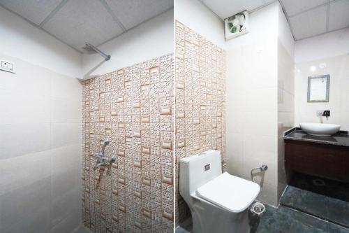 a bathroom with a white toilet and a sink at Marut Hotel in Noida