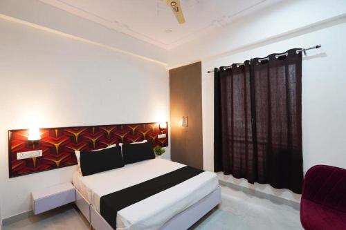 a bedroom with a bed with a painting on the wall at Marut Hotel in Noida