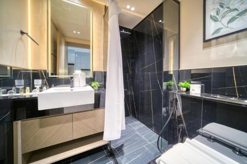 La salle de bains est pourvue d'un lavabo et d'un miroir. dans l'établissement Burj Khalifa Poolside, Canal Boardwalk, Parking, à Dubaï