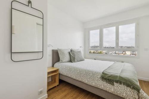 une chambre blanche avec un lit et un miroir dans l'établissement Apt neuf entierement equipe 4 pax - Faidherbe, à Paris