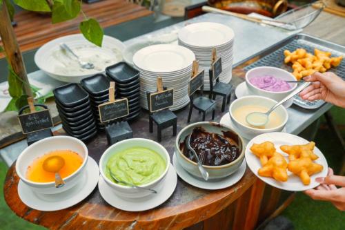 a table topped with bowls and plates of food at Maldives Beach Resort in Chao Lao Beach
