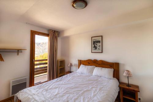 une chambre avec un lit blanc et une fenêtre dans l'établissement Résidence Les Hauts De Preclaux - Chaleureux appartement au coeur des Orres 1800 MAE-5904, aux Orres