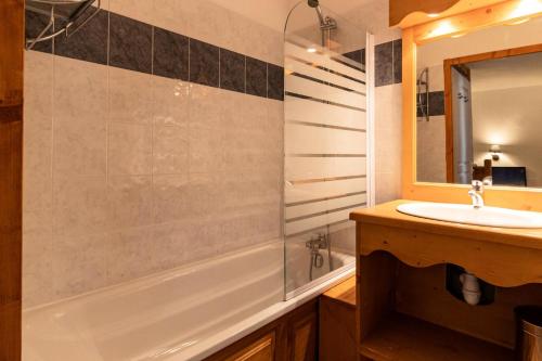 une salle de bain avec une baignoire, un lavabo et un miroir dans l'établissement Résidence Les Hauts De Preclaux - Chaleureux appartement au coeur des Orres 1800 MAE-5904, aux Orres