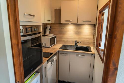 une petite cuisine avec un évier et un micro-ondes dans l'établissement Résidence Le Belvedere - Appartement 2 pièces au coeur des Orres 1650 MAE-5994, aux Orres