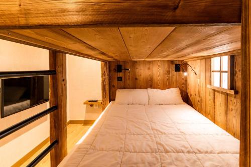 un grand lit dans une pièce en bois avec un lit dedans dans l'établissement Résidence Les Hauts De Preclaux - Chaleureux appartement neuf au coeur de la station MAE-6054, aux Orres