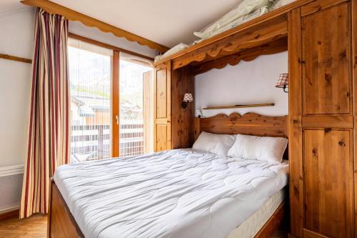 - une chambre avec un lit en bois et une grande fenêtre dans l'établissement Résidence Les Hauts De Preclaux - Appartement spacieux au coeur des Orres 1800 MAE-6064, aux Orres