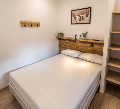 - une petite chambre avec un lit blanc et une étagère dans l'établissement Résidence Les Hauts De Preclaux - Superbe appartement offrant une vue sur les pistes MAE-6104, aux Orres