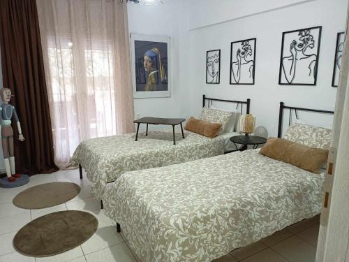 a bedroom with two beds and a table at Stefiniki Apartment in Psakoudia
