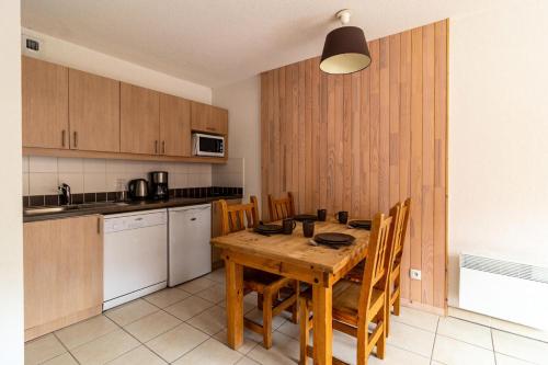 - une cuisine avec une table en bois et des placards en bois dans l'établissement Résidence Le Balcon Des Airelles - Appartement calme au coeur des Orres 1800 MAE-6444, aux Orres