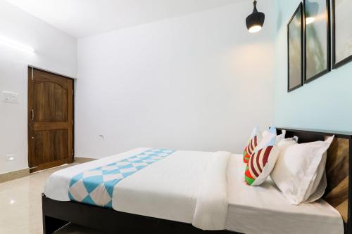 1 dormitorio con 1 cama con sábanas y almohadas blancas en OYO Flagship Sunshine 2, en Khandagiri