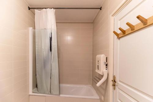 a bathroom with a tub and a shower curtain at Résidence Le Balcon Des Airelles - 2 Pièces pour 4 Personnes 364 in Les Orres