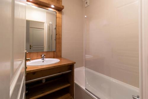 La salle de bains est pourvue d'un lavabo, d'une baignoire et d'un miroir. dans l'établissement Résidence Le Balcon Des Airelles - 2 Pièces pour 4 Personnes 504, aux Orres