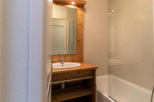 a bathroom with a sink and a mirror and a tub at Résidence Le Balcon Des Airelles - 2 Pièces pour 4 Personnes 574 in Les Orres