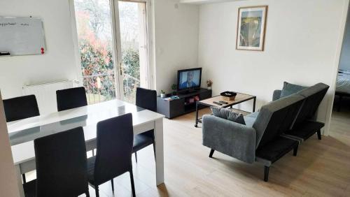 un salon avec une table et des chaises de salle à manger dans l'établissement Appartement cosy 2 chambres avec jardin, à Les Ponts-de-Cé