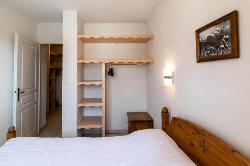 1 dormitorio con cama y estante para libros en Résidence Le Balcon Des Airelles - 2 Pièces pour 4 Personnes 634, en Les Orres
