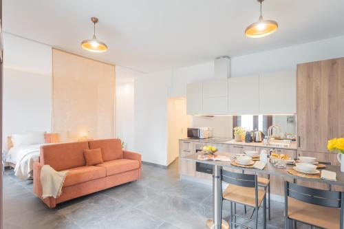 a living room and kitchen with a couch and a table at Cozy Nest on the lake by Rent All Como in Tremezzo