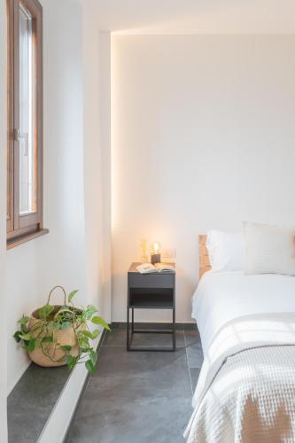 a bedroom with a bed and a table with a plant at Cozy Nest on the lake by Rent All Como in Tremezzo