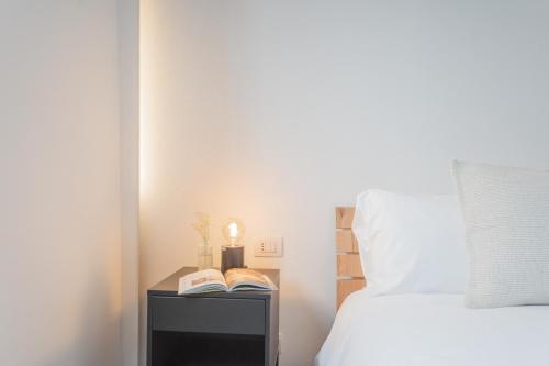 a bedroom with a bed and a nightstand with books at Cozy Nest on the lake by Rent All Como in Tremezzo