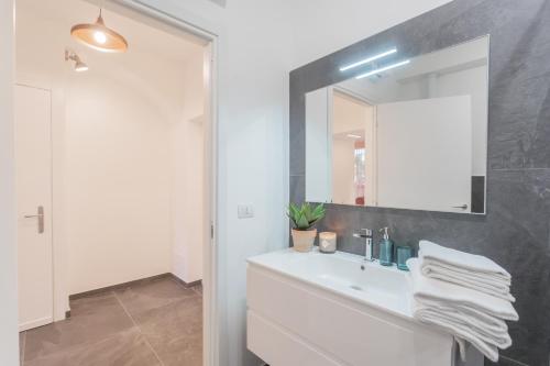 a bathroom with a white sink and a mirror at Cozy Nest on the lake by Rent All Como in Tremezzo