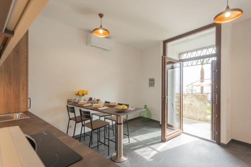 a kitchen and dining room with a table and chairs at Cozy Nest on the lake by Rent All Como in Tremezzo