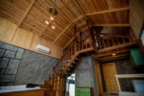 uma escada de madeira num camarote com tecto de madeira em Amazena em Çamlıhemşin