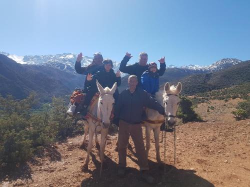 a group of people riding on donkeys on a mountain at Dar Imoughlad in Marrakesh