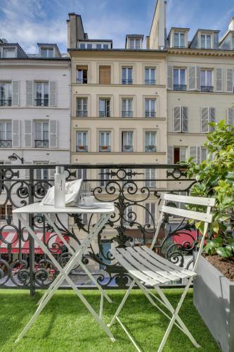 a table and chairs on a balcony with a building at Le A in Paris