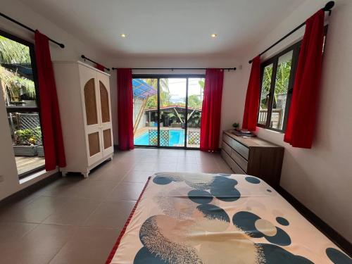 a room with a bed and a view of a pool at O’ Paradis D’Albion in Albion