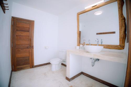 a bathroom with a sink and a toilet and a mirror at Island View Bar & Bungalow in Gili Air