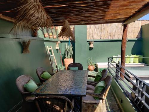 a table and chairs on the balcony of a house at Riad OLIVE Privatif 4 Personnes in Marrakesh